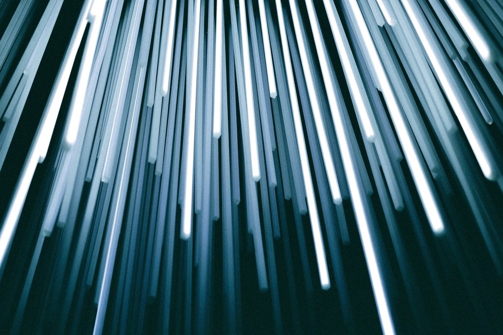 Long-exposure streaks of light falling across a dark background